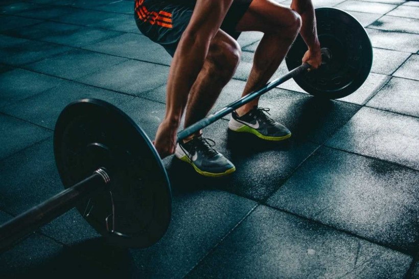 Atleta derruba barra de peso nas costas durante treino de crossfit