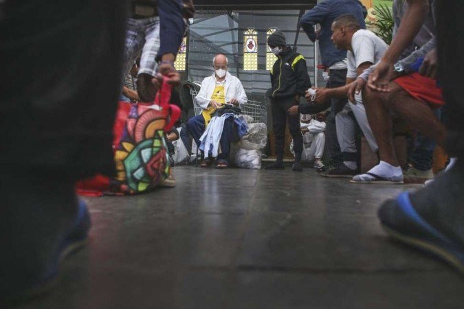 Brazilian Catholic priest Julio Lancellotti (C) distributes clothes to homeless people at the Sao Martinho de Lima Community Centre in Sao Paulo, Brazil, on May 30, 2022. - Dozens of persons enter a parish church in eastern Sao Paulo in search of food, clothes or a word of comfort, where Lancellotti makes sure nobody leaves with an empty stomach, hands or heart. (Photo by FILIPE ARAUJO / AFP) Caption - (crédito: FILIPE ARAUJO / AFP) Brazilian Catholic priest Julio Lancellotti (C) distributes clothes to homeless people at the Sao Martinho de Lima Community Centre in Sao Paulo, Brazil, on May 30, 2022. - Dozens of persons enter a parish church in eastern Sao Paulo in search of food, clothes or a word of comfort, where Lancellotti makes sure nobody leaves with an empty stomach, hands or heart. (Photo by FILIPE ARAUJO / AFP) Caption - (crédito: FILIPE ARAUJO / AFP)