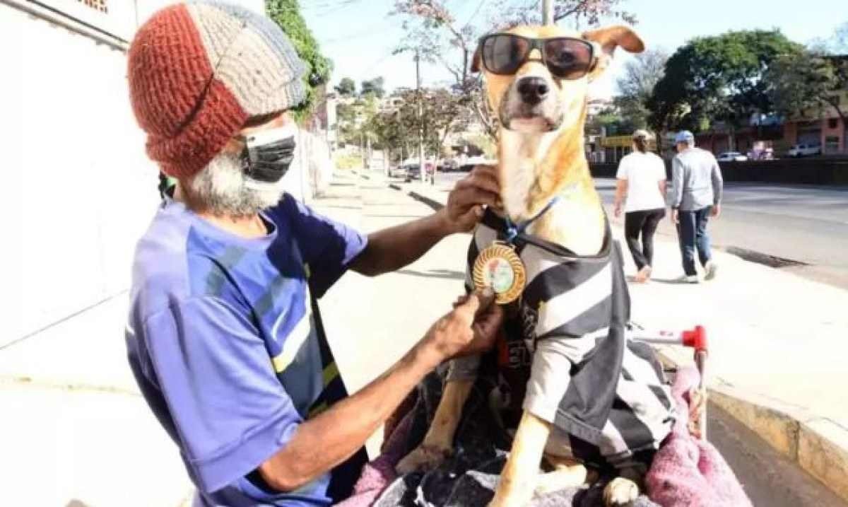 Homem em situação de rua protege cão do frio com camisa do Atlético