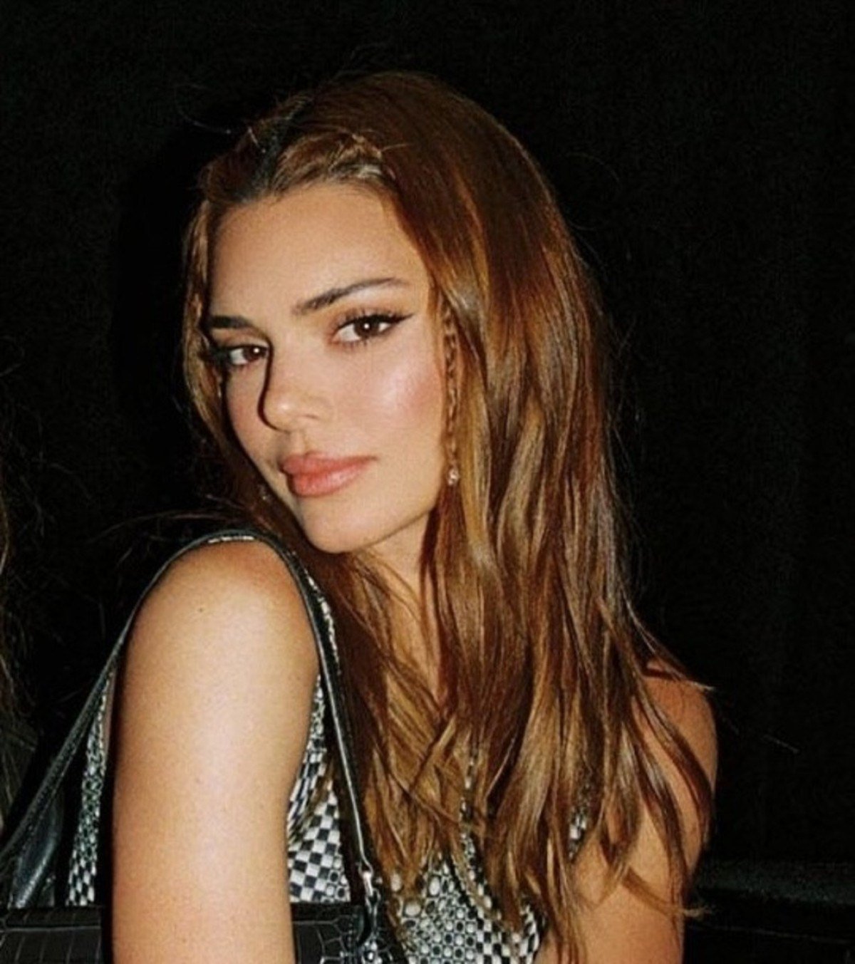 Kendall Jenner com as sobrancelhas expressivamente mais finas e com trancinhas emoldurando o rosto