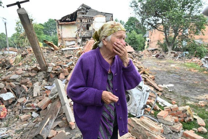 Raisa Kuva, 82 anos, chora diante de prédio destruído em bombardeio à cidade de Chuguiv, a leste de Kharkiv - (crédito: Sergey Bobok/AFP) Raisa Kuva, 82 anos, chora diante de prédio destruído em bombardeio à cidade de Chuguiv, a leste de Kharkiv - (crédito: Sergey Bobok/AFP)