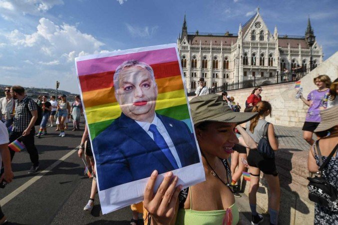 A participant holds up a made-up portrait of Hungary's President Viktor Orban during the LGBTIQA+ Pride Parade in Budapest on July 23, 2022, in memory of the Stonewall Riots, the first big uprising of homosexuals against police assaults in New York City on June 27, 1969. (Photo by Ferenc ISZA / AFP)
Caption - (crédito: FERENC ISZA / AFP) A participant holds up a made-up portrait of Hungary's President Viktor Orban during the LGBTIQA+ Pride Parade in Budapest on July 23, 2022, in memory of the Stonewall Riots, the first big uprising of homosexuals against police assaults in New York City on June 27, 1969. (Photo by Ferenc ISZA / AFP)
Caption - (crédito: FERENC ISZA / AFP)