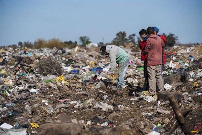 Pessoas procurando pelas notas de cem dólares no meio do lixo - (crédito: STR / AFP) Pessoas procurando pelas notas de cem dólares no meio do lixo - (crédito: STR / AFP)