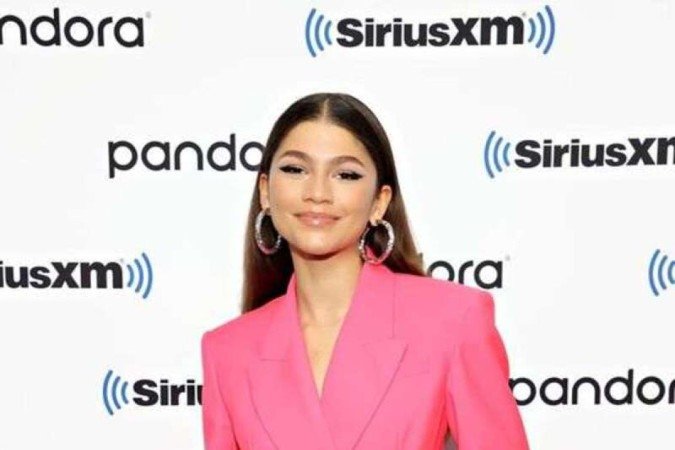 Atriz Zendaya vestindo conjunto de alfaiataria rosa em tapete vermelho
