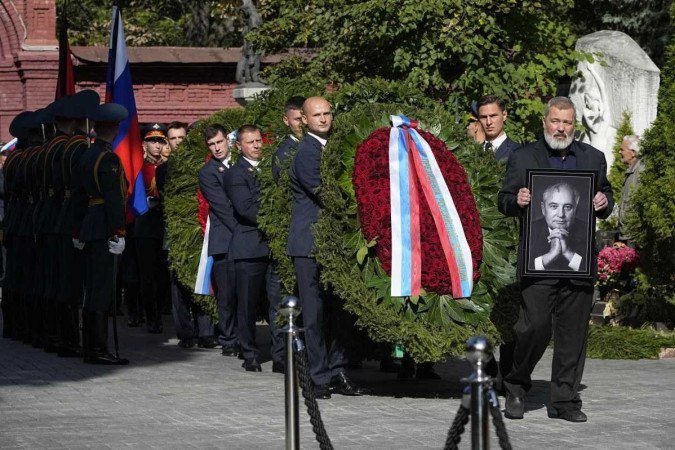  Nobel Peace Prize journalist Dmitry Muratov (R) carries a portrait of former Soviet Union President Mikhail Gorbachev during his funeral at Novodevichy Cemetery in Moscow, on September 3, 2022. - Last Soviet leader Mikhail Gorbachev was laid to rest in a Moscow ceremony, but without the fanfare of a state funeral and with the glaring absence of President Vladimir Putin. (Photo by Alexander ZEMLIANICHENKO / POOL / AFP)        -  (crédito: Alexander ZEMLIANICHENKO / POOL / AFP)