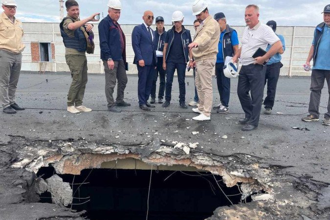 Técnicos da AIEA observam buraco em prédio que abriga combustível nuclear e rejeitos radioativos, em Zaporizhzhia  -  (crédito: Fredrik Dahl/AIEA/AFP)