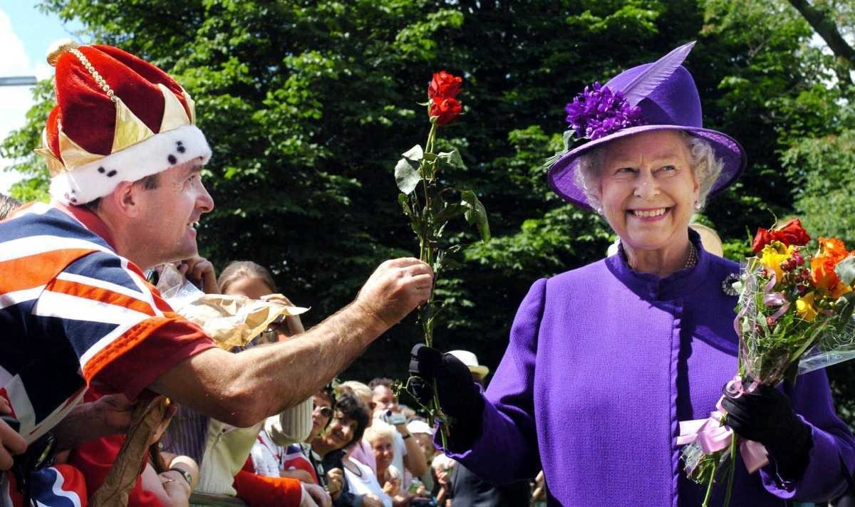 Elizabeth II quebrou os protocolos da monarquia britânica e institui a "caminhada entre plebeus". Quanto ela podia, ela ficava perto dos cidadãos do país e dos países em que visitava. Na foto, de julho de 2004, ela se aproxima e oferece uma rosa a um britânico após uma cerimônia oficial em um parque de Londres