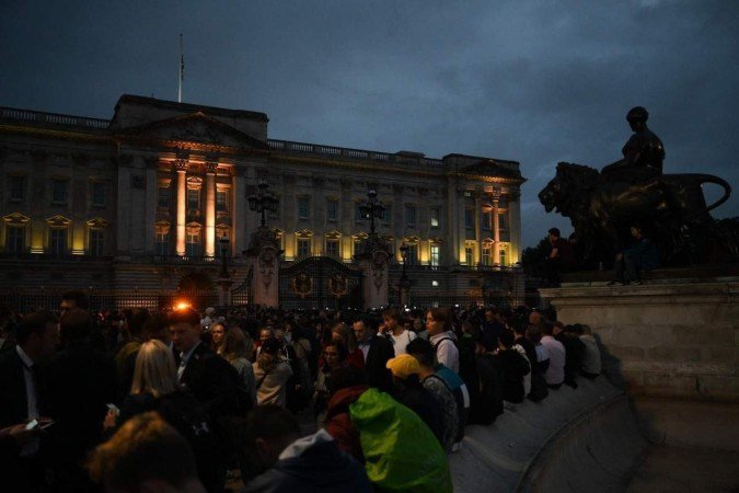 Multidão faz vigília em frente ao Palácio de Buckingham -  (crédito:  AFP)