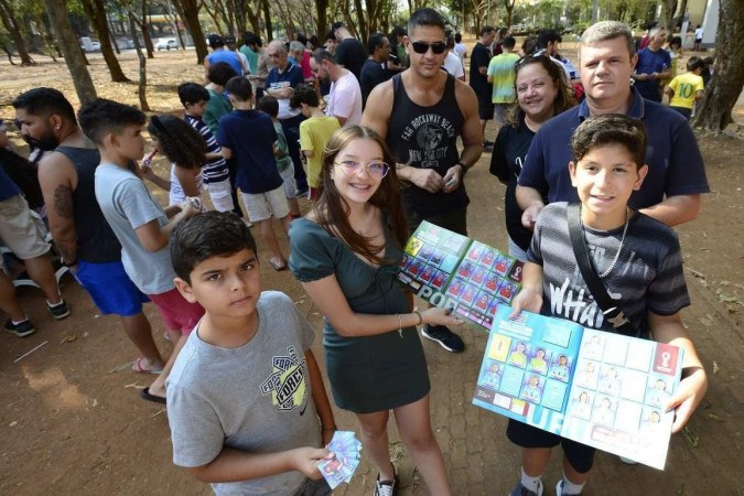  18/09/2022 Crédito: Marcelo Ferreira/CB/D.A Press. Brasil. Brasilia - DF -  Troca de figurinhas da Copa 2022 na  Banca do Brito na 106 Norte. Familias trocando figurinha, Larissa  Santos com os pais Cheila Santos e Jason Neves  e a outra família Rodrigo Araújo  (camiseta) com os filhos Luiz Felipe (camisa cinza) e Ricardo Godoy (camisa listrada). -  (crédito:  Marcelo Ferreira/CB/D.A Press)