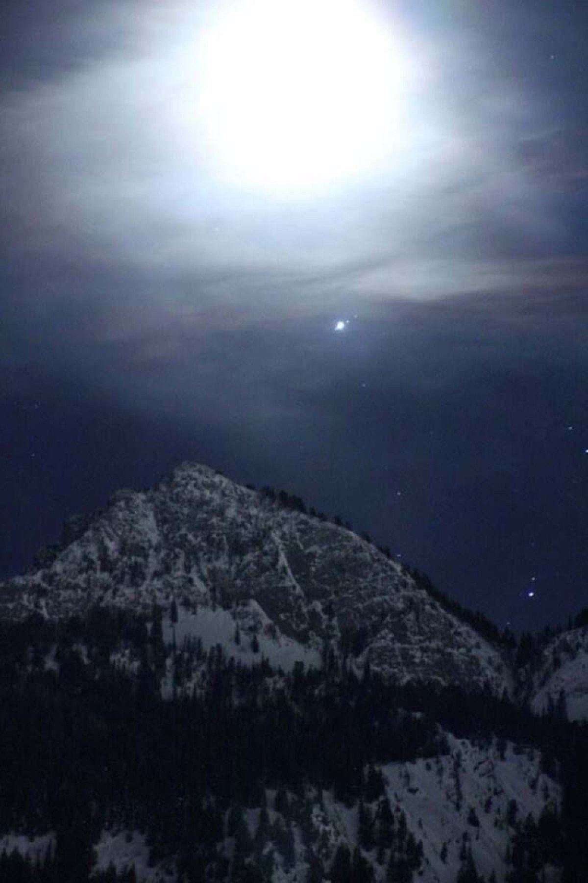 Jupiter and its three largest moons are visible as the moon rises over the Wasatch Mountains near Salt Lake City on February 27, 2019.  Astronomers should get a similar view of Jupiter during opposition on Monday (9/26)