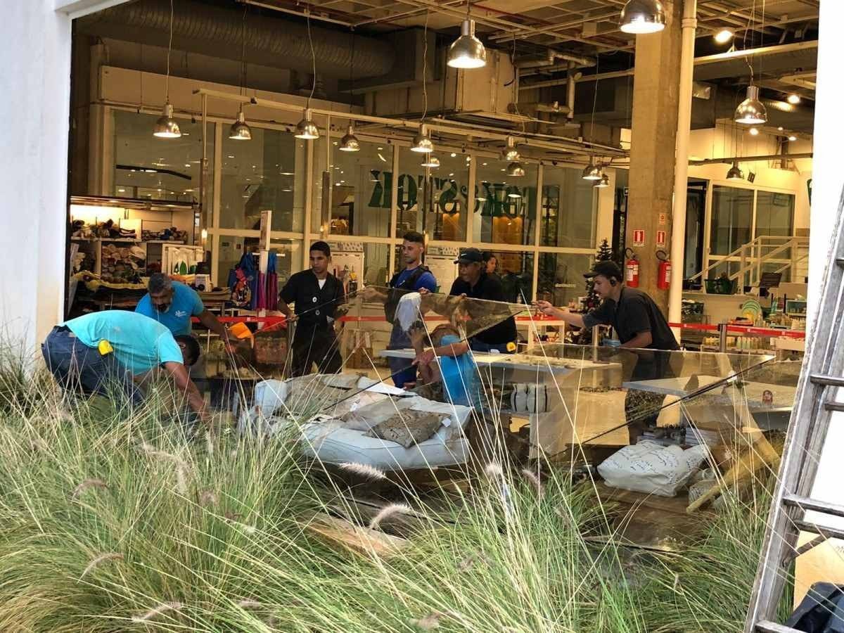 Funcionários da loja e do shopping trabalham para recolocar os vidros