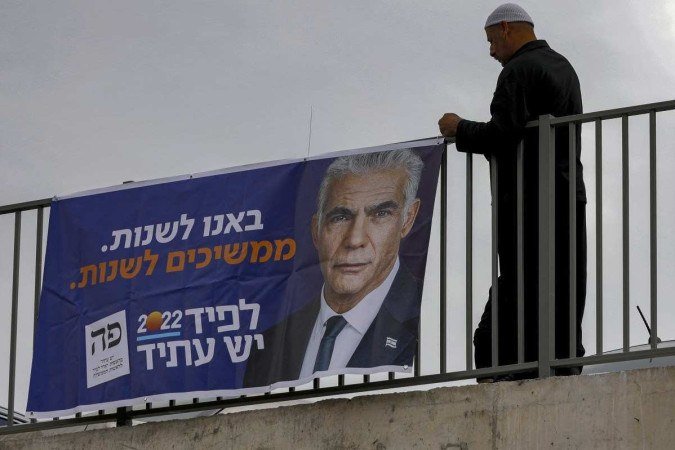 Homem pendura faixa do premiê Yair Lapid em aldeia drusa de Yarka