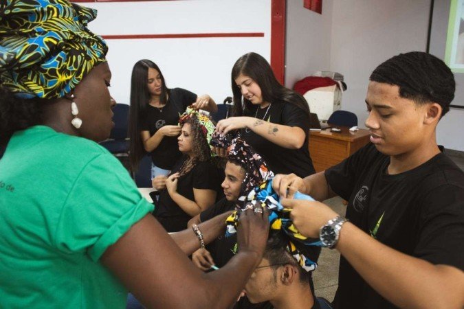 Os estudantes em aula prática sobre penteados afro