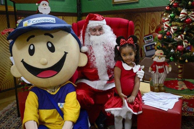 Lis Costa de Araújo, 4 anos, filha de um servidor dos Correios, tira foto com Papai Noel