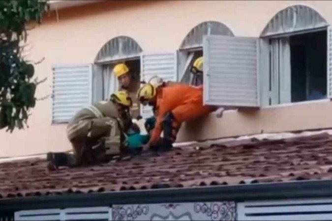 Bombeiros tiram mulher que subiu no telhado da casa de Alexandre Leal da Silva, que ficou conhecido como Alexandre do Guará - (crédito: Reprodução/Redes Sociais) Bombeiros tiram mulher que subiu no telhado da casa de Alexandre Leal da Silva, que ficou conhecido como Alexandre do Guará - (crédito: Reprodução/Redes Sociais)