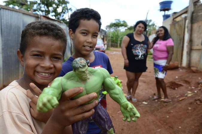 Fredy e Victor Beto brincando com o boneco do Hulk com as mães atrás   -  (crédito:  Marcelo Ferreira/CB/D.A Press)