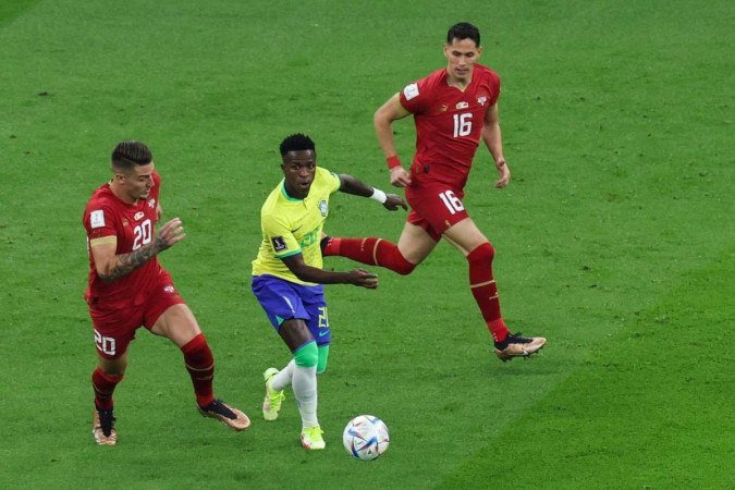  Brazil's forward #20 Vinicius Junior carries the ball as he is followed by Serbia's midfielder #20 Sergej Milinkovic-Savic and Serbia's midfielder #16 Sasa Lukic during the Qatar 2022 World Cup Group G football match between Brazil and Serbia at the Lusail Stadium in Lusail, north of Doha on November 24, 2022. (Photo by Giuseppe CACACE / AFP)
      