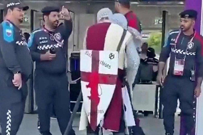 O vídeo do momento em que os homens são barrados na porta do estádio viralizou nas redes sociais. Os dois, assim como outros torcedores ingleses, usavam uma túnica com a cruz de São Jorge, cota de malha cinza, capacetes e espadas e escudos de brinquedo. - (crédito: Reprodução @thecasualultra/ Twitter) O vídeo do momento em que os homens são barrados na porta do estádio viralizou nas redes sociais. Os dois, assim como outros torcedores ingleses, usavam uma túnica com a cruz de São Jorge, cota de malha cinza, capacetes e espadas e escudos de brinquedo. - (crédito: Reprodução @thecasualultra/ Twitter)