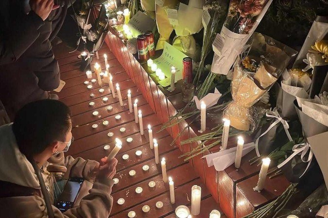 Também na capital chinesa. um memorial com flores e velas foi montado para homenagear vítimas do incêndio em Urumqi