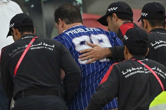 Torcedor norte-americano sendo escoltado para longe das arquibancadas do Estádio Al Thumama