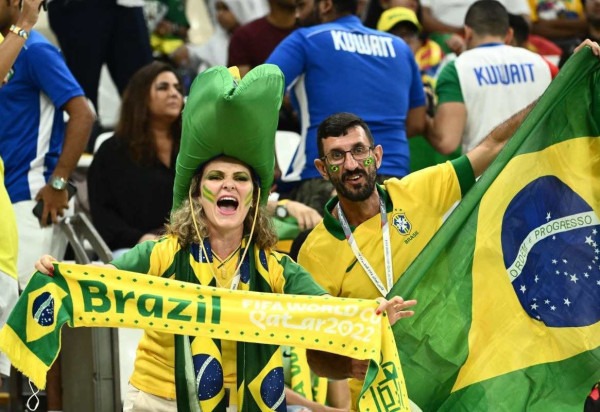 Torcedores do Brasil seguram lenços e bandeiras nas arquibancadas antes da partida de futebol do entre Camarões e Brasil no Estádio Lusail em Lusail, em 2 de dezembro de 2022. -  (crédito: Jewel SAMAD / AFP)
