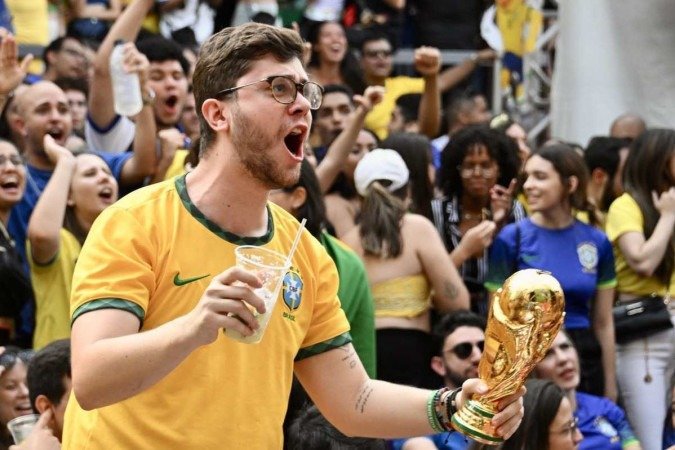  A fan of Brazil reacts while watching the live broadcast of the Qatar 2022 World Cup round of 16 football match between Brazil and South Korea at a bar in Brasilia on December 05, 2022. (Photo by EVARISTO SA / AFP)
      Caption 