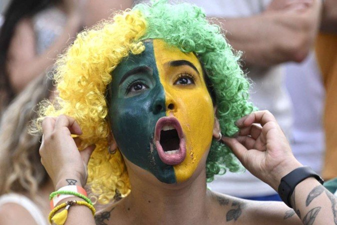  Fans of Brazil react while watching the live broadcast of the Qatar 2022 World Cup round of 16 football match between Brazil and South Korea at a bar in Brasilia on December 5, 2022. (Photo by EVARISTO SA / AFP)
      Caption 