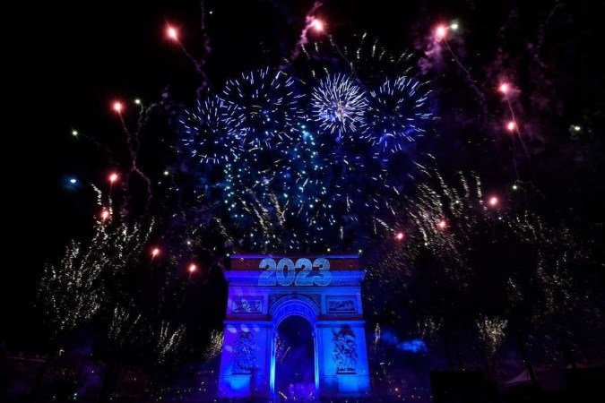 Fogos de artifício explodem ao lado do Arco do Triunfo, na Avenue des Champs-Elysees durante as comemorações do Ano Novo em Paris