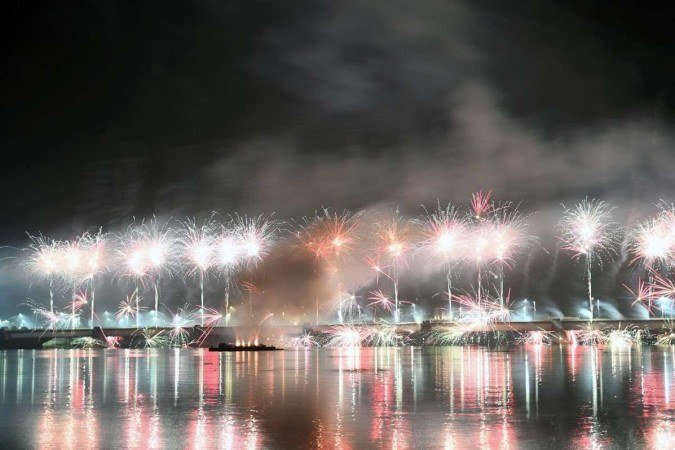 Fogos de artifício são lançados sobre a Lagoa Ebrie e a ponte General de Gaulle durante a celebração do Ano Novo em Abidjan, na Costa do Marfim