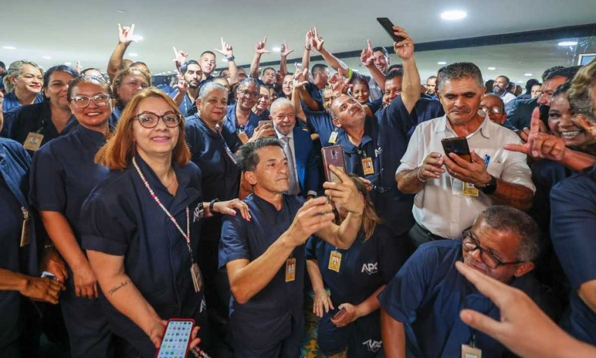 Lula repete gesto habitual em mandatos e posa ao lado de trabalhadores