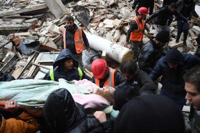 Syrian civil defence carry an injured woman after rescuing her from the rubble of a collapsed building after an earthquake in the government-controlled Aleppo on February 6, 2023. - A 7.8-magnitude earthquake hit Turkey and Syria early on February 6, killing hundreds of people as they slept, levelling buildings and sending tremors that were felt as far away as the island of Cyprus, Egypt and Iraq. (Photo by AFP) Caption - (crédito: AFP) Syrian civil defence carry an injured woman after rescuing her from the rubble of a collapsed building after an earthquake in the government-controlled Aleppo on February 6, 2023. - A 7.8-magnitude earthquake hit Turkey and Syria early on February 6, killing hundreds of people as they slept, levelling buildings and sending tremors that were felt as far away as the island of Cyprus, Egypt and Iraq. (Photo by AFP) Caption - (crédito: AFP)