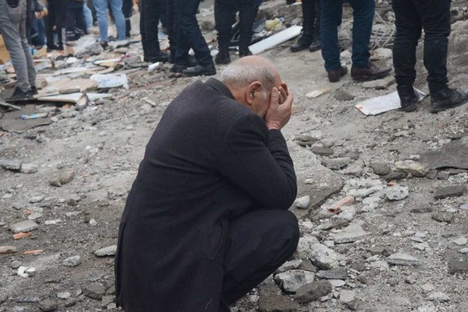 Um homem reage com desespero enquanto as pessoas procuram sobreviventes nos escombros em Diyarbakir, na Turquia, depois que um terremoto de magnitude 7,8 atingiu o sudeste do país, em 6 de fevereiro de 2023 -  (crédito: ILYAS AKENGIN / AFP)