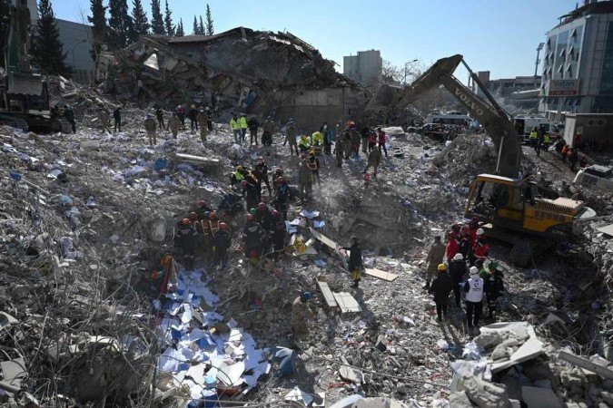  Search and rescue teams search the rubble of collapsed buildings in Kahramanmaras on February 14, 2023, a week after an earthquake devastated parts of Turkey and Syria leaving more than 35,000 dead and millions in dire need of aid. - Kahramanmaras (Photo by OZAN KOSE / AFP)
      