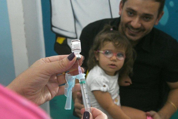  24/02/2023 Credito: Ed Alves/CB/DA.Press. Cidades. Vacinação contra Covid 19. Posto de saude 114/115 Norte. Na foto, Antonio Francisco Ribeiro Neto e sua filha Livia Ribeiro. 