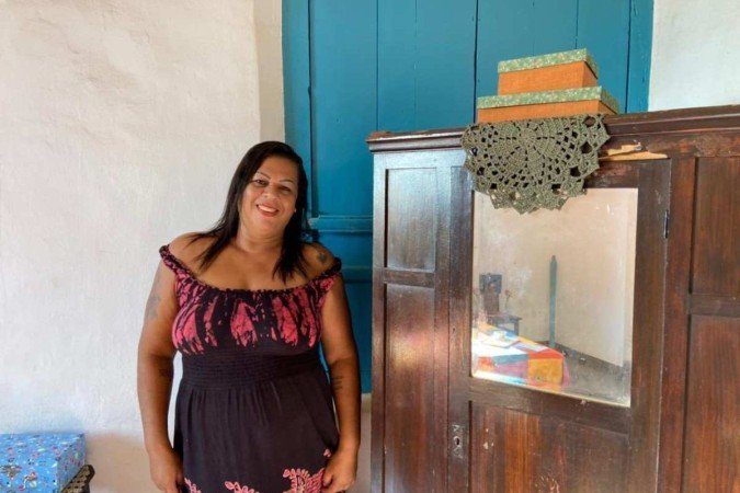 Jaciara Santos, 44, pousa ao lado de caixas artesanais produzidas por ela para a exposição