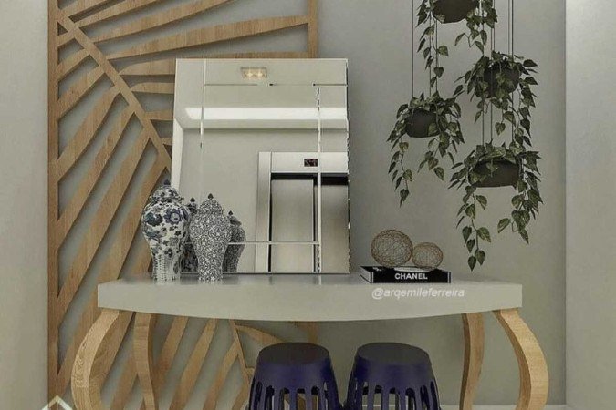 Hall de entrada com aparador, espelho e plantas, da arquiteta Emile Ferreira. O projeto mostra que uma simples entrada pode se transformar em um ponto de atenção na casa
