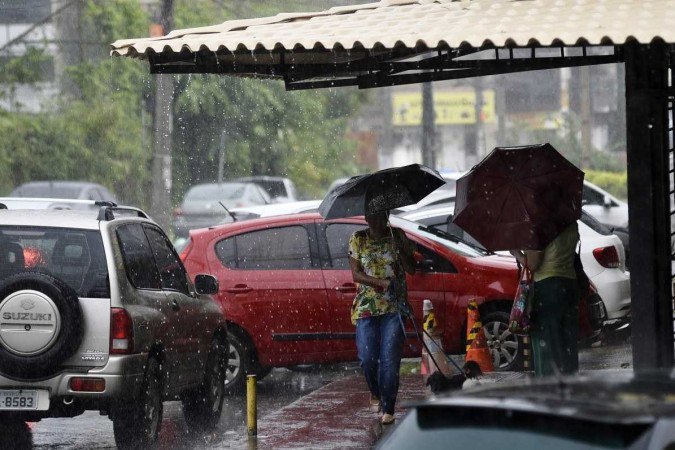 Mulheres se protegem da chuva, no Guará. - (crédito: Minervino Júnior/CB/D.A.Press) Mulheres se protegem da chuva, no Guará. - (crédito: Minervino Júnior/CB/D.A.Press)