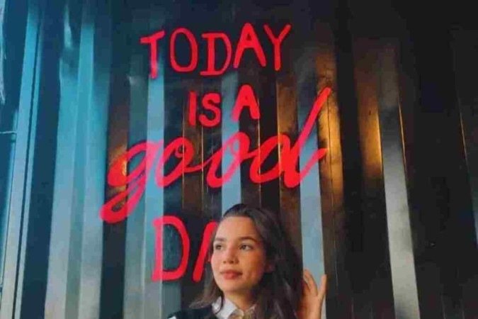  Amanda Barradas combina short jeans, camiseta branca manga longa e colete de tricô para um passeio casual