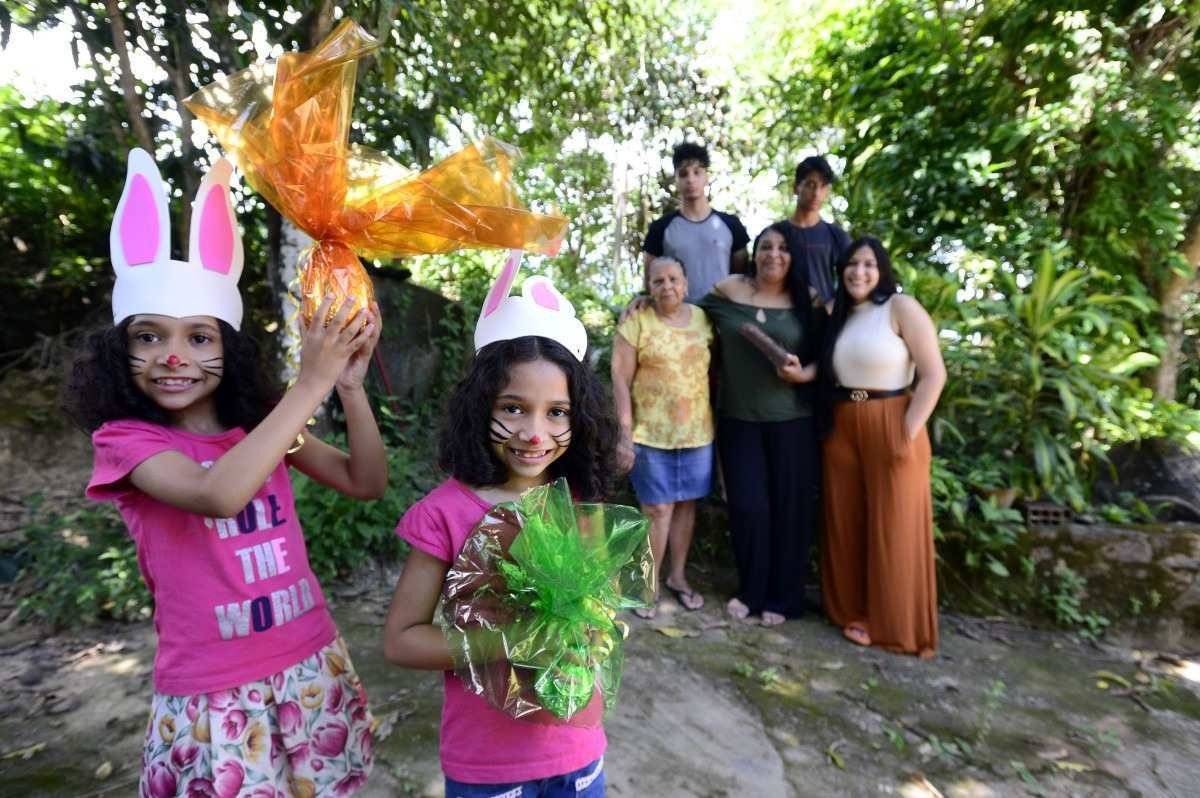  29/03/2023 Crédito: Marcelo Ferreira/CB/D.A Press. Brasil. Brasilia - DF - Histórias de famílias que cultivam a tradição de decorar o lar, realizar brincadeiras e fazer receitas de família para deixar a data mais especial. Avó Sra Rosana Sousa (vestido amarelo) com a filha Julia Sousa  (camisa escura) e netos as gêmeas Ana Luiza e Mamuela Aquilar , Iza Carvalho e Thiago Carvalho (camisa manga preta) e Christian Carvalho.