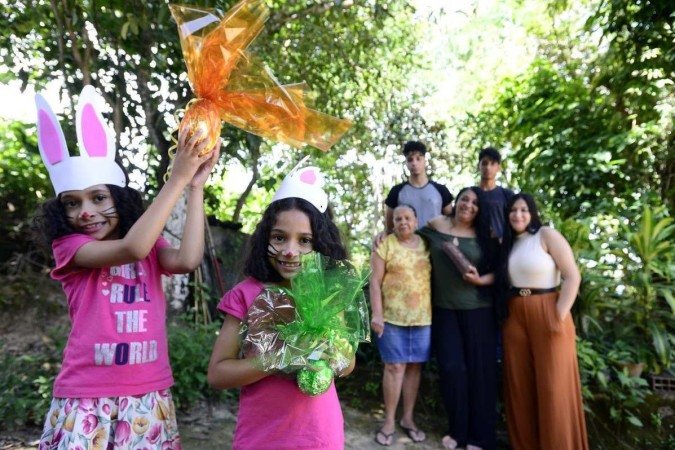  29/03/2023 Crédito: Marcelo Ferreira/CB/D.A Press. Brasil. Brasilia - DF - Histórias de famílias que cultivam a tradição de decorar o lar, realizar brincadeiras e fazer receitas de família para deixar a data mais especial. Avó Sra Rosana Sousa (vestido amarelo) com a filha Julia Sousa  (camisa escura) e netos as gêmeas Ana Luiza e Mamuela Aquilar , Iza Carvalho e Thiago Carvalho (camisa manga preta) e Christian Carvalho.