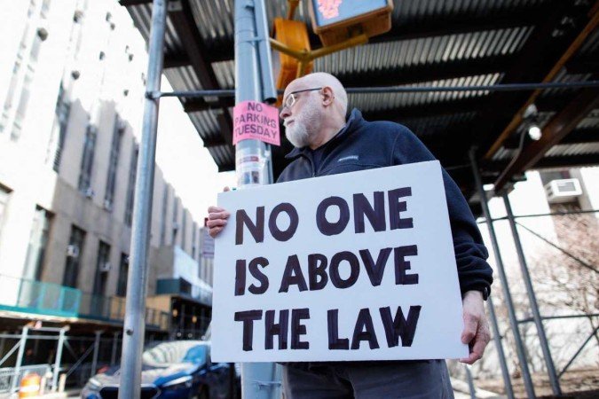 Manifestante segura cartaz com a frase 