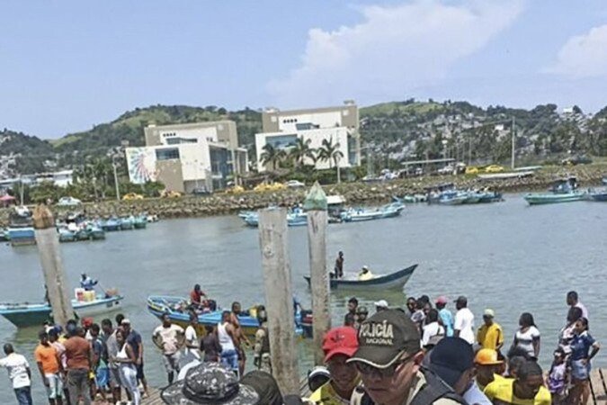 Policiais carregam ferido em tiroteio no porto de Esmeraldas (norte)