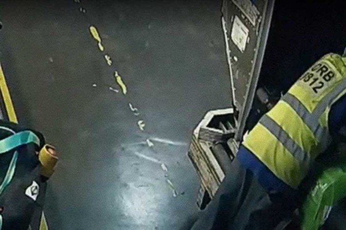 Momento em que funcionário troca etiquetas de malas de brasileiras que estavam em contêiner, em São Paulo - (crédito: Reprodução/Fantástico) Momento em que funcionário troca etiquetas de malas de brasileiras que estavam em contêiner, em São Paulo - (crédito: Reprodução/Fantástico)