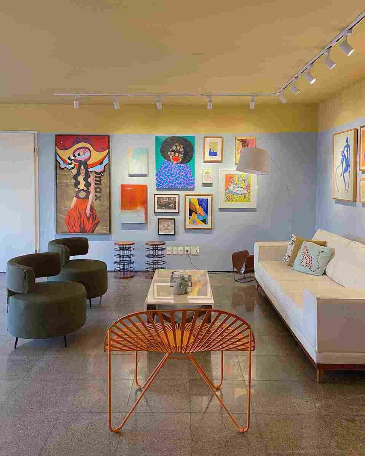  Quadros coloridos na parede e escultura sobre a mesa em sala de estar