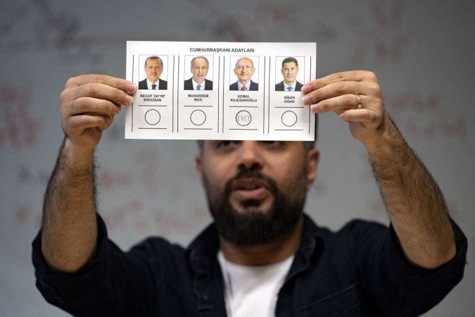 Funcionário de seção eleitoral mostra voto, durante contagem, também em Istambul: cédulas de papel 