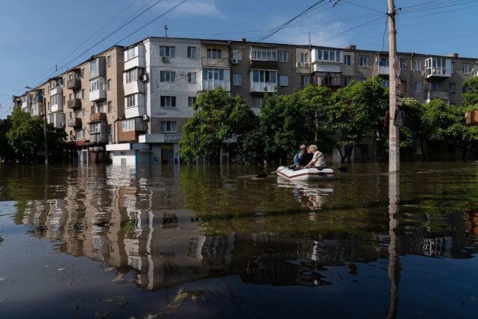 Forças de segurança ucranianas transportam moradores retirados de área inundada de Kherson - (crédito: Aleksey Filippov/AFP) Forças de segurança ucranianas transportam moradores retirados de área inundada de Kherson - (crédito: Aleksey Filippov/AFP)