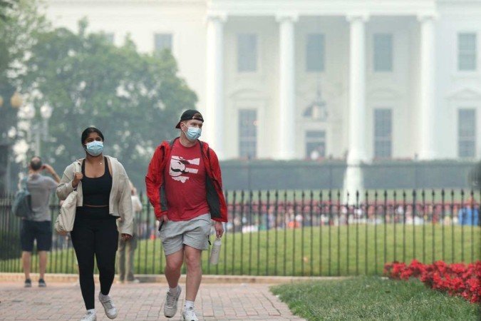 Moradores da capital utilizam máscara, em frente à Casa Branca  