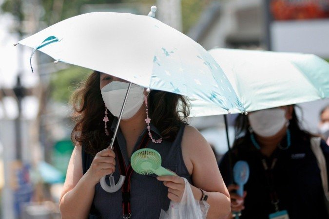 Mulheres usando apetrechos contra o calor em Bangkok, Tailândia -  (crédito: RUNGROJ YONGRIT/EPA-EFE/REX/Shutterstock)
