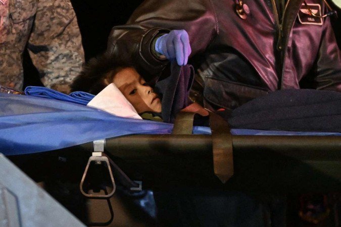 Um dos irmãos é transportado em maca, após desembarque na Base Militar Catam, de Bogotá, na madrugada de ontem