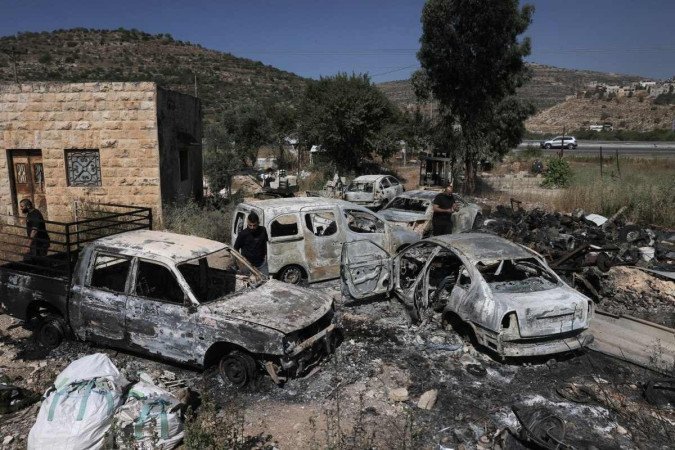 Carros queimados por colonos israelenses na área de Al-Lubban Al-Sharqiya, em retaliação a ataque que matou quatro judeus, na terça-feira  -  (crédito: Ahmad Gharabli/AFP)
